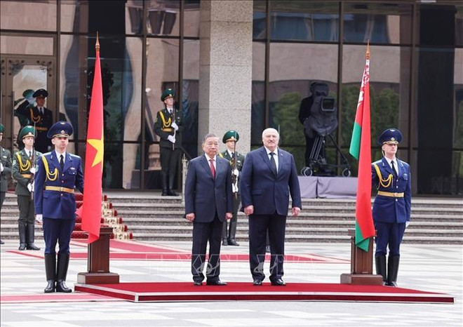 Le président biélorusse, Alexandre Loukachenko et le secrétaire général du Parti, Tô Lâm (gauche), en visite d’État en Biélorussie, lors de la cérémonie. Photo: VNA vna-potal-le-don-tong-bi-thu-to-lam-tham-cap-nha-nuoc-toi-belarus-stand.jpg