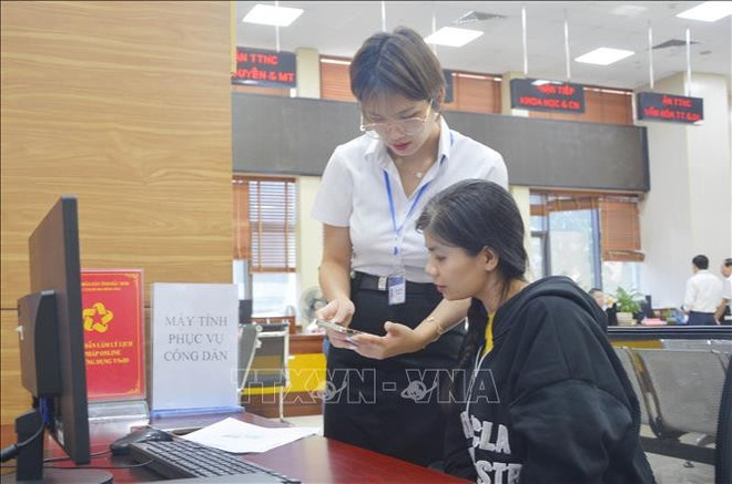 Une femme aidée à effectuer des procédures administratives en ligne au Centre de services de l'administration publique de la province de Bac Ninh. Photo: VNA bac-ninh-2225-1.jpg