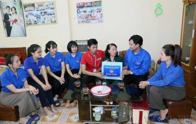 Des jeunes de la province de Son La rendent visite à Lê Thi Tam, invalide et victime de l'agent orange, et lui offrent des cadeaux. Photo : VNA anh-3.jpg