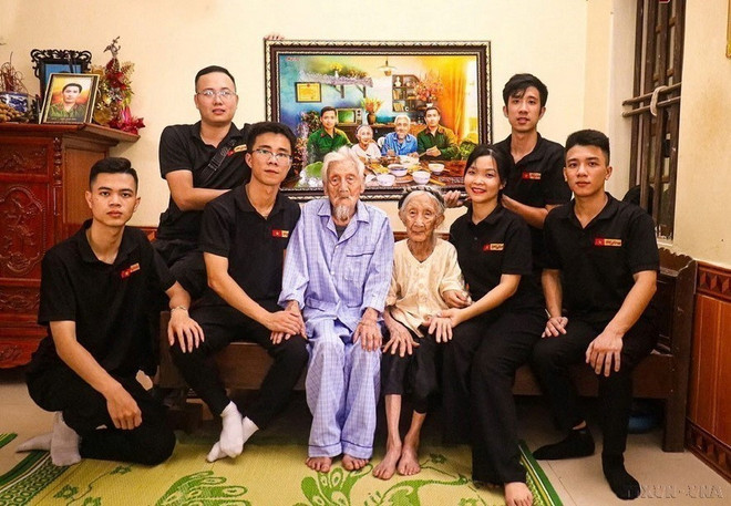 L'équipe de restauration de photos Skyline offre à la mère héroïne Nguyên Thi Ngach, une photo simulant un repas de retrouvailles avec ses deux fils. Photo : VNA anh-11.jpg