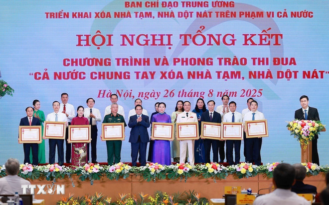 Le Premier ministre Phạm Minh Chính remet l’Ordre du Travail de troisième classe à des collectifs ayant obtenu des résultats remarquables dans le mouvement d’émulation “Tout le pays uni pour éliminer les habitations précaires et délabrées”. Photo: VNA chung-tay-xoa-nha-tam.jpg