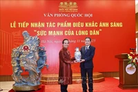 Le président de l'Assemblée nationale, Tran Thanh Man, remet un cadeau à l'artisan Bui Van Tu. Photo : VNA