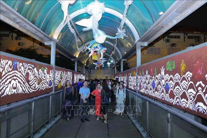 Placées sur le thème « Eau », les installations artistiques sur le pont piétonnier Tran Nhat Duat le transforment en un « aquarium coloré et animé » avec des lumières et des dessins 3D. Photo: VNA