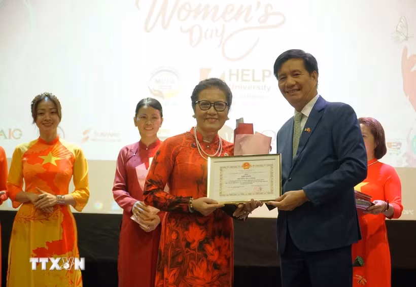 L'ambassadeur du Vietnam en Malaisie, Dinh Ngoc Linh, remis un certificat de mérite à Mme Tran Thi Chang, présidente de l'Association d'amitié Malaisie-Vietnam, lors de la célébration. Photo : VNA