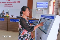 Une femme venue pour effectuer les démarches administratives au Centre de services de l'administration publique de la commune de Xuan Hong, à Ninh Binh. Photo : VNA