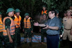 Le Premier ministre inspecte les opérations de lutte contre les inondations dans la nuit. Photo : VNA