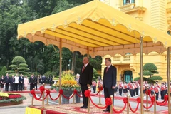 Le Secrétaire général To Lam et le Premier secrétaire et président cubain Miguel Díaz-Canel Bermúdez à la tribune, écoutant la fanfare militaire jouer les hymnes nationaux des deux pays. Photo : VNA