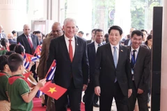 Le président Luong Cuong (droite) et le premier secrétaire du Comité central du Parti communiste de Cuba, président cubain, Miguel Díaz-Canel Bermúdez au grand meeting marquant le 65ᵉ anniversaire de l’établissement des relations diplomatiques entre le Vietnam et Cuba. Photo : VNA