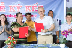 Mme Thi Khui, cheffe de la coopérative agricole d’anacarde biologique de Trang Co – Bu Lach, signe un accord de coopération pour l'achat de noix de cajou avec un représentant de la sarl Intersnack Vietnam. Photo : Journal Dong Nai