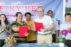 Mme Thi Khui, cheffe de la coopérative agricole d’anacarde biologique de Trang Co – Bu Lach, signe un accord de coopération pour l'achat de noix de cajou avec un représentant de la sarl Intersnack Vietnam. Photo : Journal Dong Nai