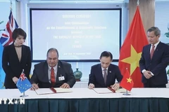 Le Hoai Trung (droite), ministre vietnamien par intérim des Affaires étrangères et Paulson Panapa, ministre des Affaires étrangères, du Travail et du Commerce de Tuvalu, signent un communiqué conjoint sur l’établissement des relations diplomatiques entre la République socialiste du Vietnam et Tuvalu. Photo : VNA