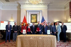 La cérémonie de signature d'un protocole d'accord entre des représentants vietnamiens et américains. Photo : VNA