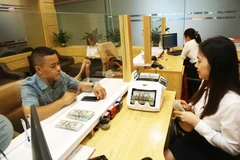 Des clients effectuent des transactions à la Banque pour l'agriculture et le développement rural (Agribank). Photo : Hanoimoi