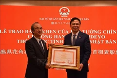 L'ambassadeur du Vietnam au Japon, Pham Quang Hieu (droite), a remis le certificat d'honneur du Premier ministre au gouverneur de la préfecture de Niigata, Hanazumi Hideyo. Photo : VNA