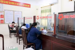 Des gens effectuent des démarches administratives au service "guichet unique" de la commune de Nhat Tan, district de Kim Bang, province de Ha Nam. Photo : VNA
