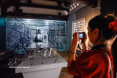 Des visiteurs découvrent l'exposition « Histoire de la pierre », qui mêle techniques traditionnelles et numériques. Photo : VNA