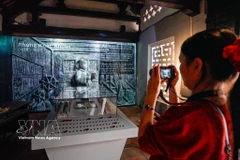 Des visiteurs découvrent l'exposition « Histoire de la pierre », qui mêle techniques traditionnelles et numériques. Photo : VNA