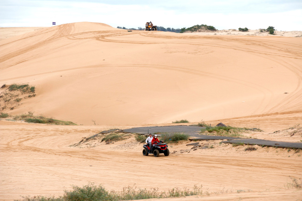 Des touristes en véhicule tout-terrain explorent les pittoresques dunes de Bau Trang (commune de Hoa Thang), au sein de la zone touristique nationale de Mui Ne. Photo : VNA