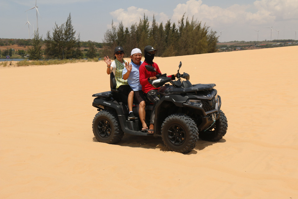 Les touristes font l'expérience de motos tout-terrain pour explorer les dunes. Photo : VNA