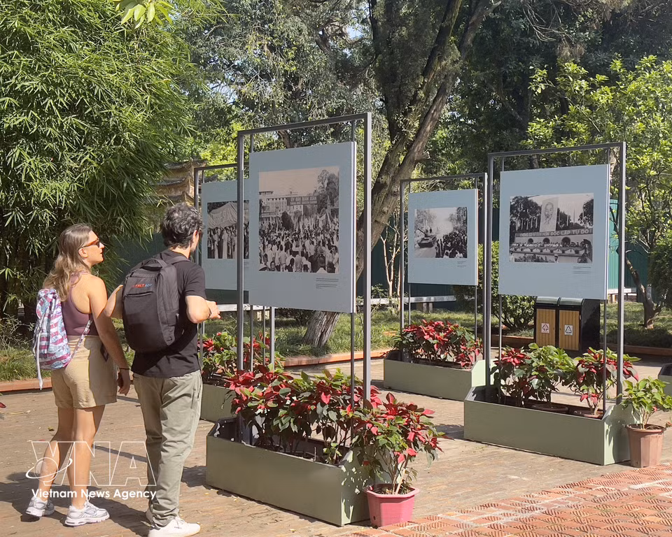 Des touristes internationaux visitent l’exposition photographique « Résonances d’un jour nouveau » à la Citadelle impériale de Thang Long. Photo: VNA