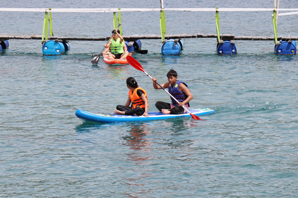 Les touristes s'essaient à l'aviron dans la baie de Vinh Hy. Photo : VNA