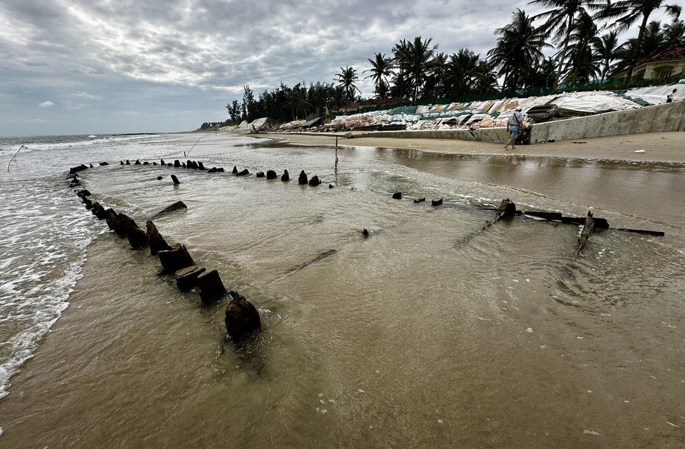 L’épave en bois apparaît et disparaît au gré des vagues et du sable marin. Photo: VNA