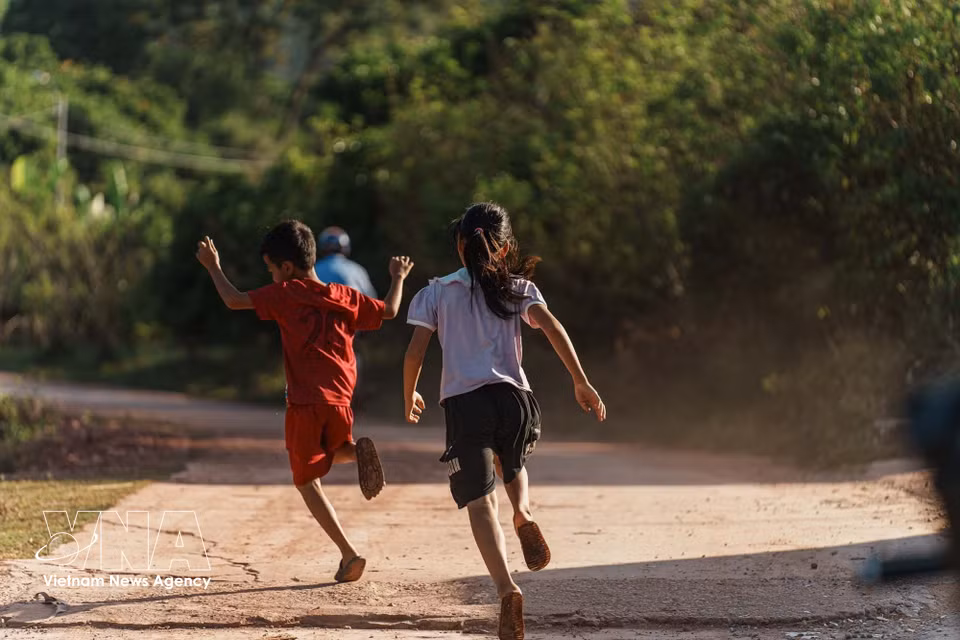 Sur un chemin du village, des enfants jouent, donnant vie à une scène empreinte de calme et d’authenticité. Photo: VNA