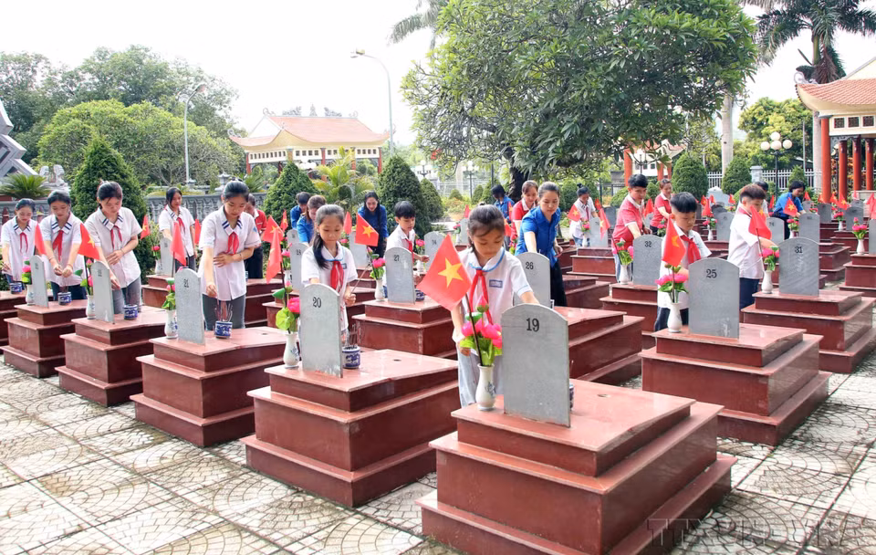 Les enfants et les membres de l’Union de la jeunesse communiste Hô Chi Minh de la province de Son La brûlent de l'encens pour commémorer les martyrs héroïques. Photo : VNA