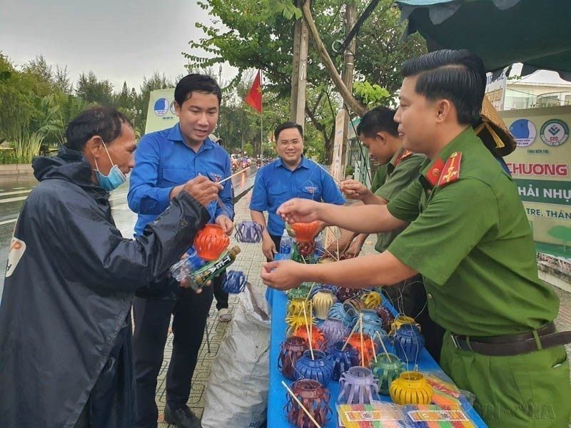 Des gens apportent des bouteilles en plastique usagées, des canettes et de vieilles piles pour les échanger contre des lanternes de la fête de la mi-automne dans le cadre d'un programme appelant les gens à trier les déchets plastiques, contribuant ainsi à la construction d'une Bên Tre verte. Photo : VNA