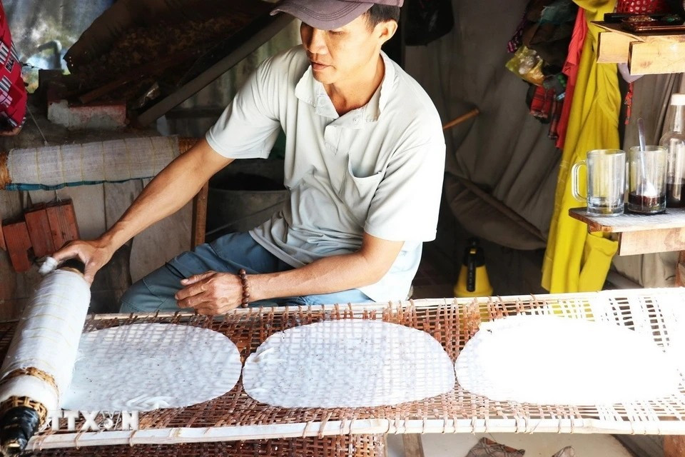 Nguyên Van Tai, hameau de Hâu Thuân, commune de Hâu Thanh, district de Cai Be, province de Tiên Giang, posent les papiers de riz sur tamis pour le séchage. Photo : VNA