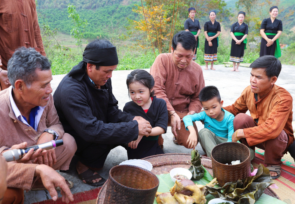 Les enfants reçoivent un fil noué au poignet par le maître des rituels et les anciens du village, puis sont officiellement intégrés dans la lignée familiale. Photo : VNA