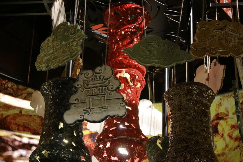 Cette imposante lampe en bronze est une véritable ode aux métiers d'art traditionnels. Sa surface est ornée de reliefs minutieux représentant une multitude de scènes de la vie quotidienne des artisans de la fonderie, de la forge, de l'orfèvrerie, de la broderie, de la fonte du bronze, de la fabrication de papier votif, de la sculpture de sceaux... Photo : VNA