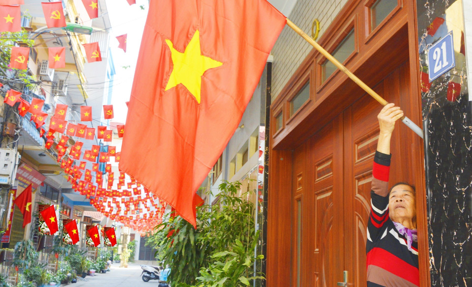 Les habitants du quartier de Kinh Bac, province de Bac Ninh, hissent les drapeaux pour célébrer le 14e Congrès national du Parti.