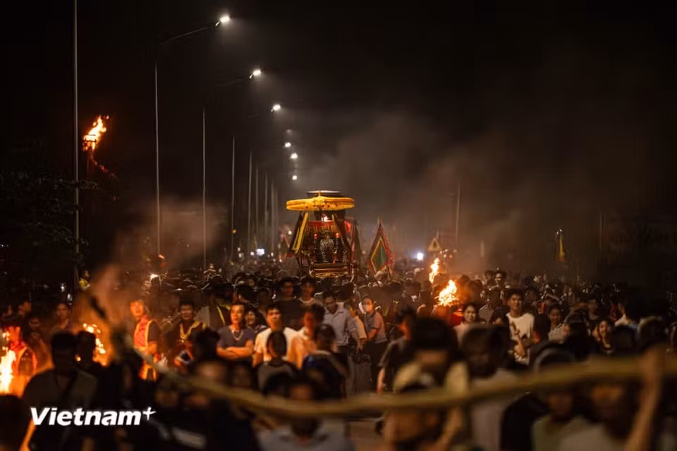Les torches s’embrasent au fur et à mesure de l’avancée du génie, comme pour lui ouvrir la voie. Malgré l’obscurité, l’ensemble du ciel alentour est illuminé par leur lueur. Photo : Vietnam+