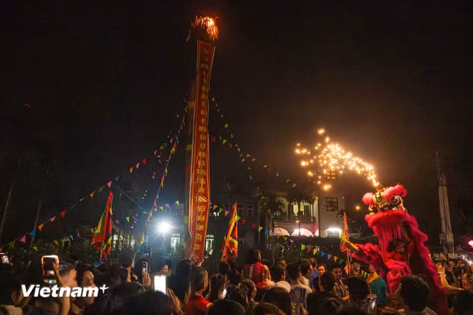 Une torche est dressée à l’entrée du village, où les habitants admirent avec enthousiasme les flammes qui s’élèvent dans la nuit. Photo : Vietnam+