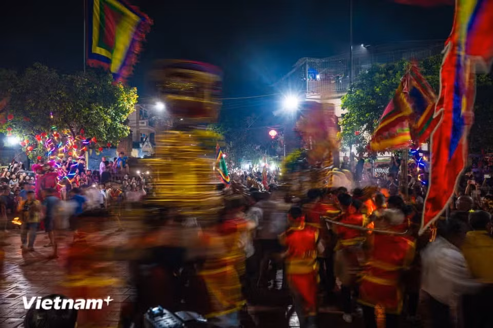 À l’arrivée du palanquin dans l’enceinte de la maison communale, les porteurs le font tourner, offrant un spectacle impressionnant et singulier. Photo : Vietnam+