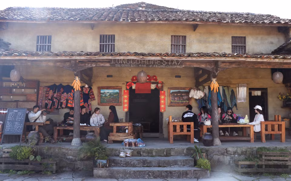 Les touristes s'imprègnent de l'espace culturel traditionnel au village de Lo Lo Chai. Photo : VNA