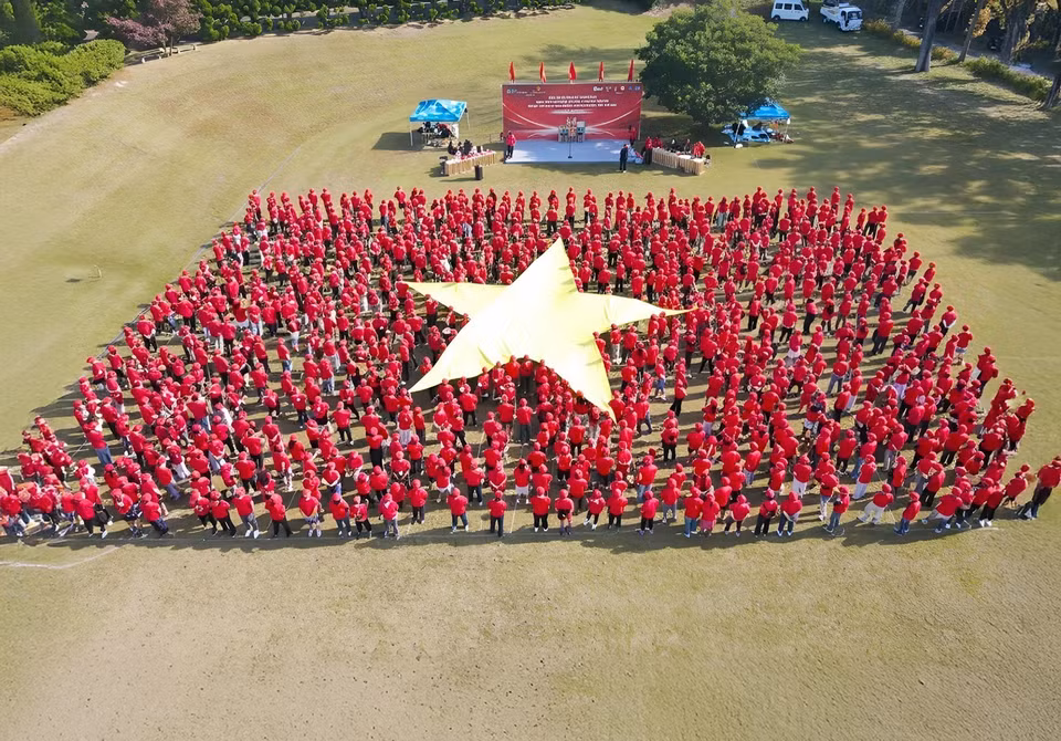 Image du drapeau national vietnamien formé par 15 groupes représentant 15 composantes de la communauté, avec plus de 1 000 participants. Photo : VNA