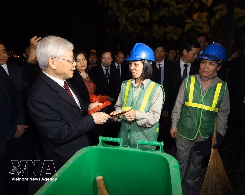 Le secrétaire général du Parti et président Nguyen Phu Trong rend visite et offre des présents aux agents de la propreté urbaine travaillant la nuit du Nouvel An lunaire du Cochon 2019 dans la zone du lac Hoan Kiem.