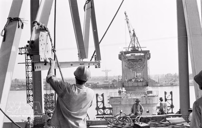 Au fil de l’histoire nationale, de nombreux ouvrages emblématiques portent l’empreinte de l’intelligence et du savoir-faire vietnamiens. Certains sont le fruit de la recherche scientifique appliquée, tandis que d’autres incarnent la cristallisation de l’intelligence collective, du courage et du travail acharné des travailleurs vietnamiens. Sur la photo : des ouvriers de la société de construction de ponts N° 11 installent en urgence les dernières sections du pont de Thang Long.