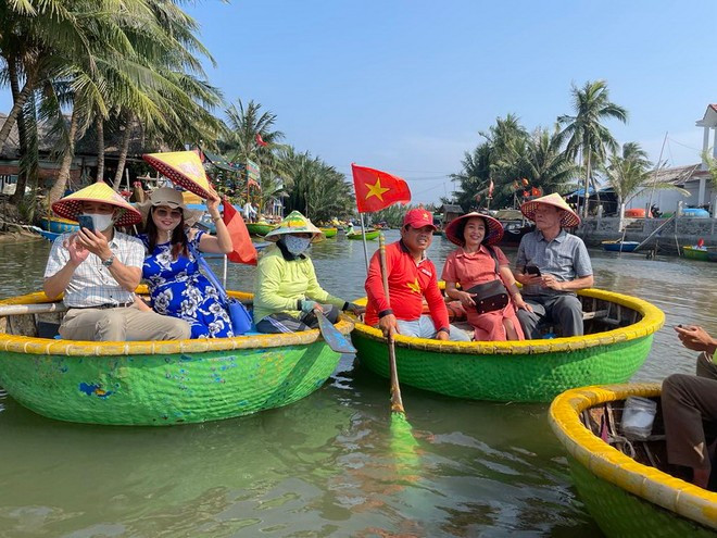 Des visiteurs profitent d’une balade en bateau rond en bambou au cœur de la forêt de cocotiers de Bay Mau, à Hoi An. Photo: VNA