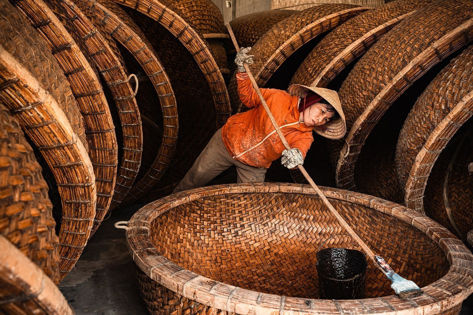 La technique d’étanchéification, transmise de génération en génération, utilise un mélange de bouse fraîche et de résine de l’arbre "dầu rai". Elle confère au bateau sa couleur caractéristique, le protège des termites et garantit une durée de vie de 4 à 5 ans en milieu marin. Photo: VNA
