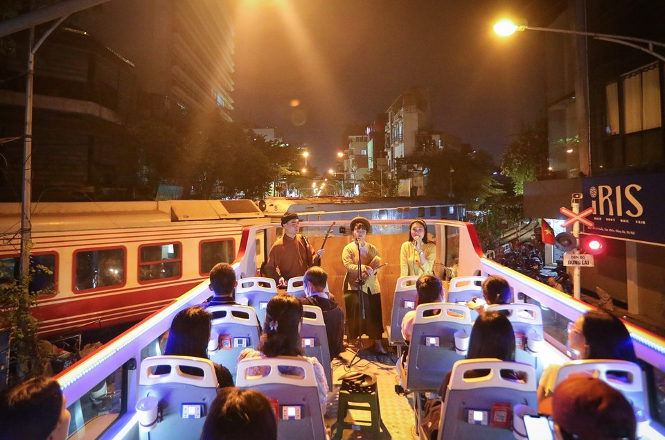 Les touristes peuvent admirer les paysages nocturnes scintillants de la capitale et écouter les airs anciens du Xam interprétés par de jeunes artistes, tout en découvrant cet art unique. Photo : VNA