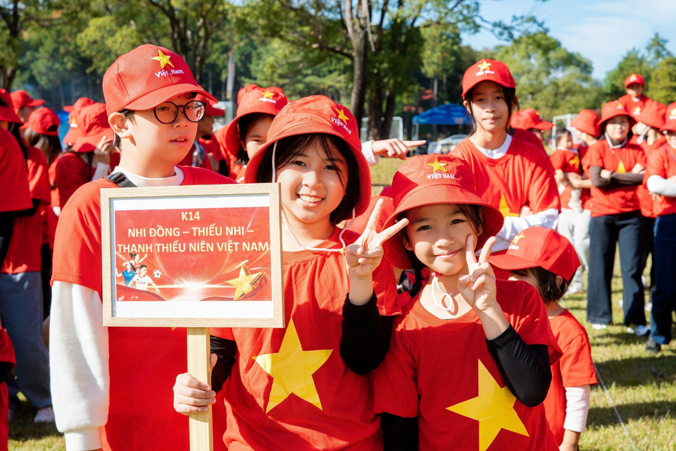 Un groupe de jeunes Vietnamiens participe à la formation du drapeau national. Photo : VNA