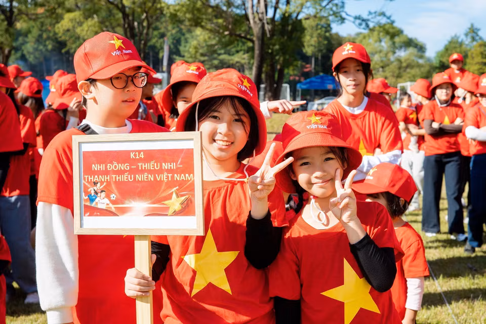 Un groupe de jeunes Vietnamiens participe à la formation du drapeau national. Photo : VNA