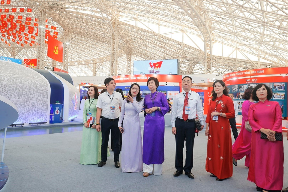 La directrice générale de la VNA Vu Viêt Trang (ao dai violet) et les délégués à l'espace d'exposition sur le parcours de 80 ans de la VNA au Centre des expositions du Vietnam à Dông Anh.