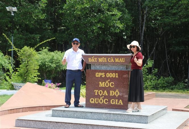 Des visiteurs prennent des photos souvenir au repère géographique national du cap Cà Mau, commune de Dât Mui. Photo : VNA