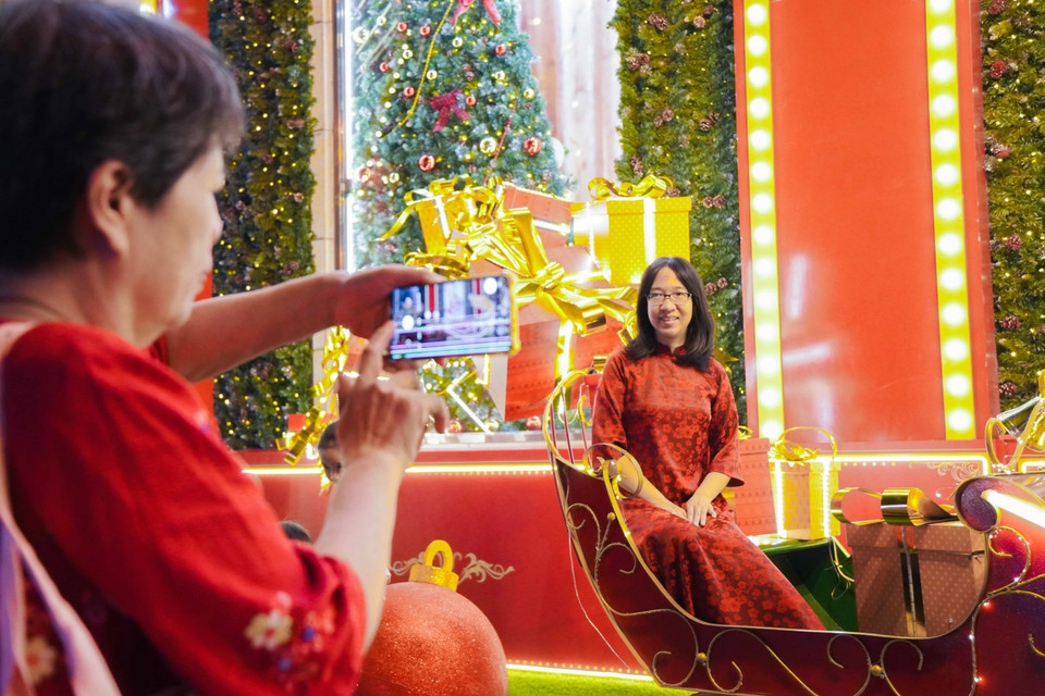 De nombreuses personnes choisissent le rouge comme couleur principale pour capturer les moments de Noël. Photo : VNA