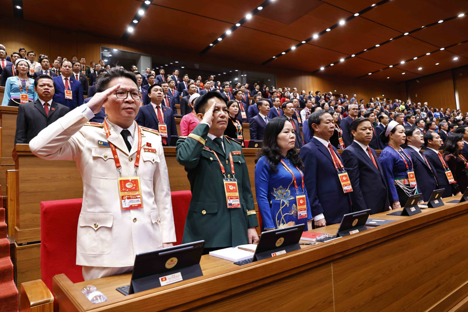 Des délégués procèdent à la levée du drapeau. Photo : VNA