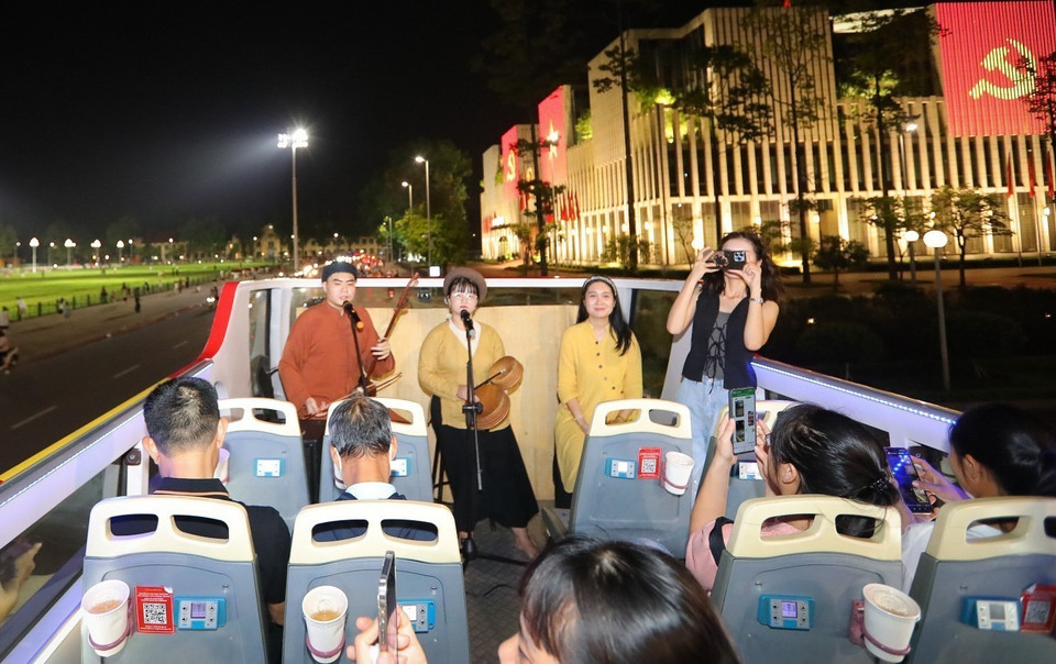 Les touristes peuvent admirer les paysages nocturnes scintillants de la capitale et écouter les airs anciens du Xam interprétés par de jeunes artistes, tout en découvrant cet art unique. Photo : VNA